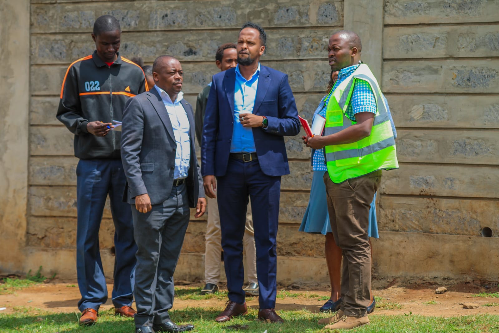 Technical team briefing at the stadium perimeter wall