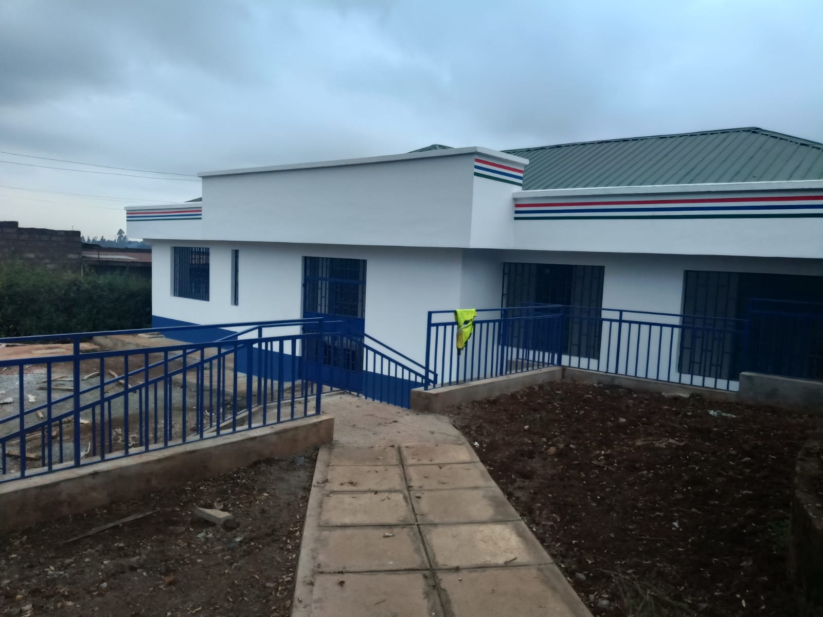 Completed exterior of the Gathanji Dispensary with painted walls, blue railings and access walkway