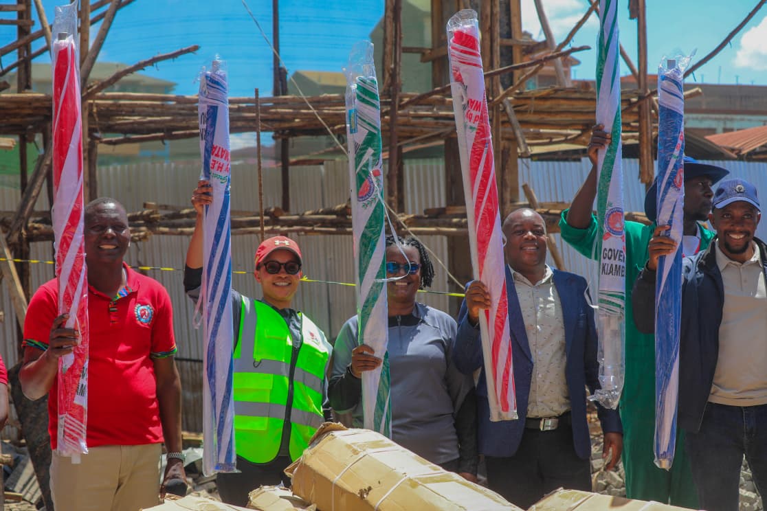 Leaders and traders holding new market umbrellas at Githunguri Market